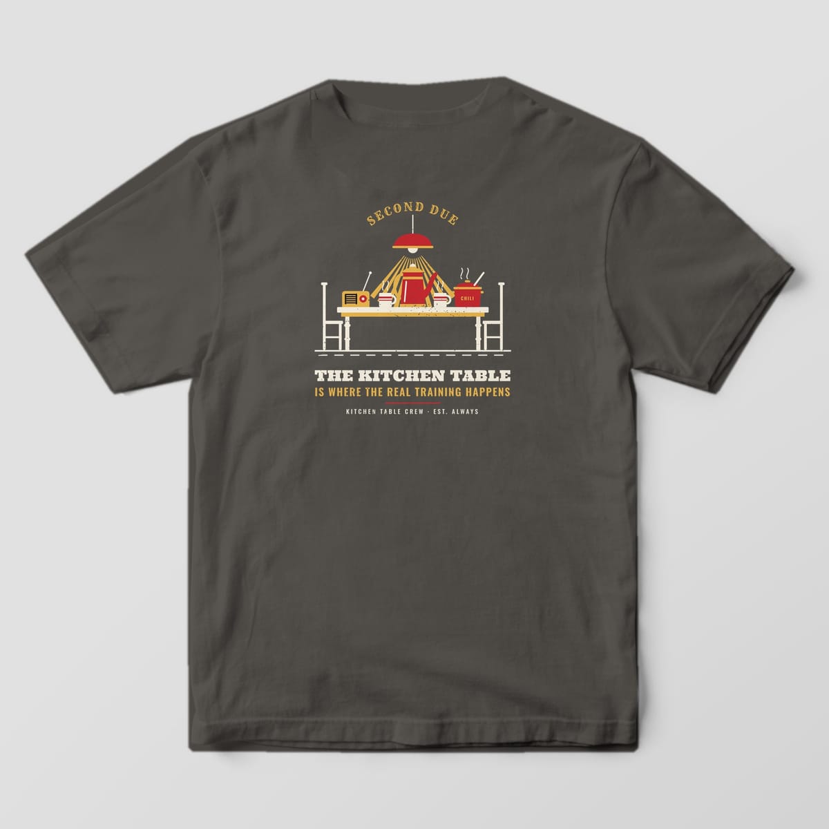 Back of a pepper Comfort Colors tee with a kitchen table, percolator, mugs and chili pot under a lamp, plus the real training happens quote
