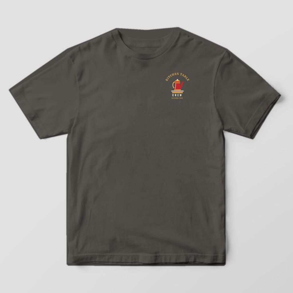 Front of a pepper Comfort Colors tee with a small red coffee percolator on a burner and Kitchen Table Crew text