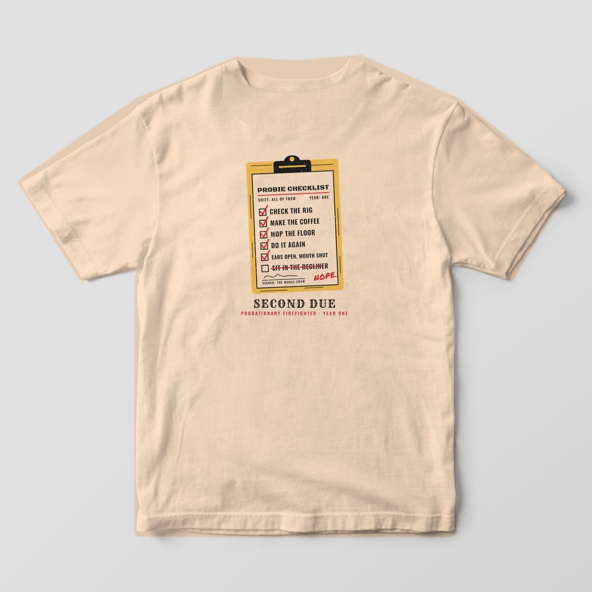 Back of an ivory Comfort Colors tee printed with a clipboard probie checklist with red check marks and a crossed-out recliner line