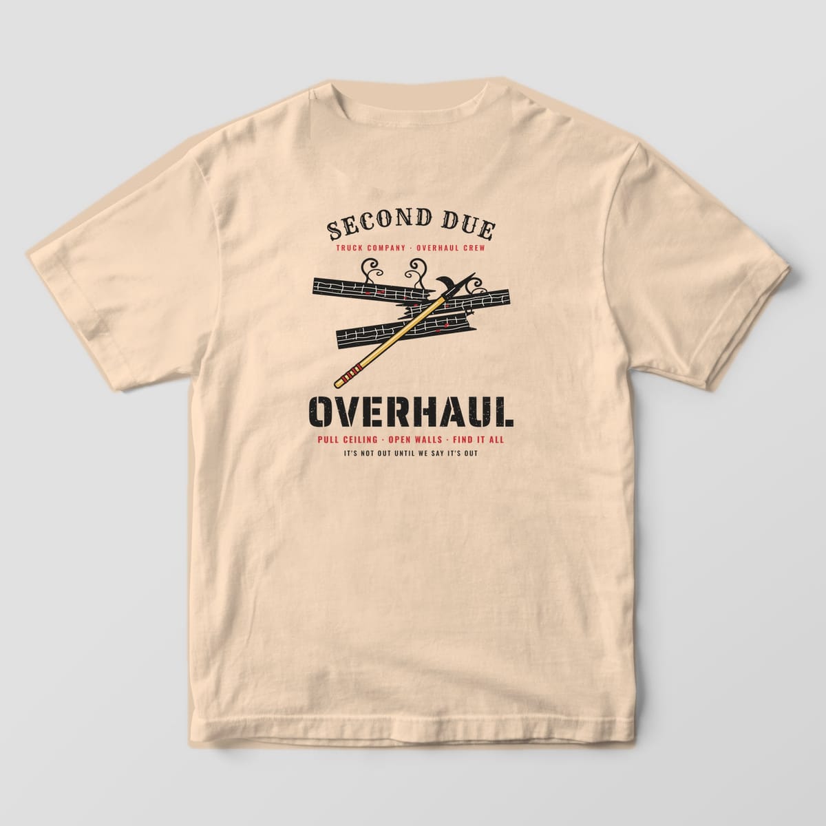 Back of an ivory Comfort Colors tee with a gold pike pole pulling charred black joists and a black stencil Overhaul headline