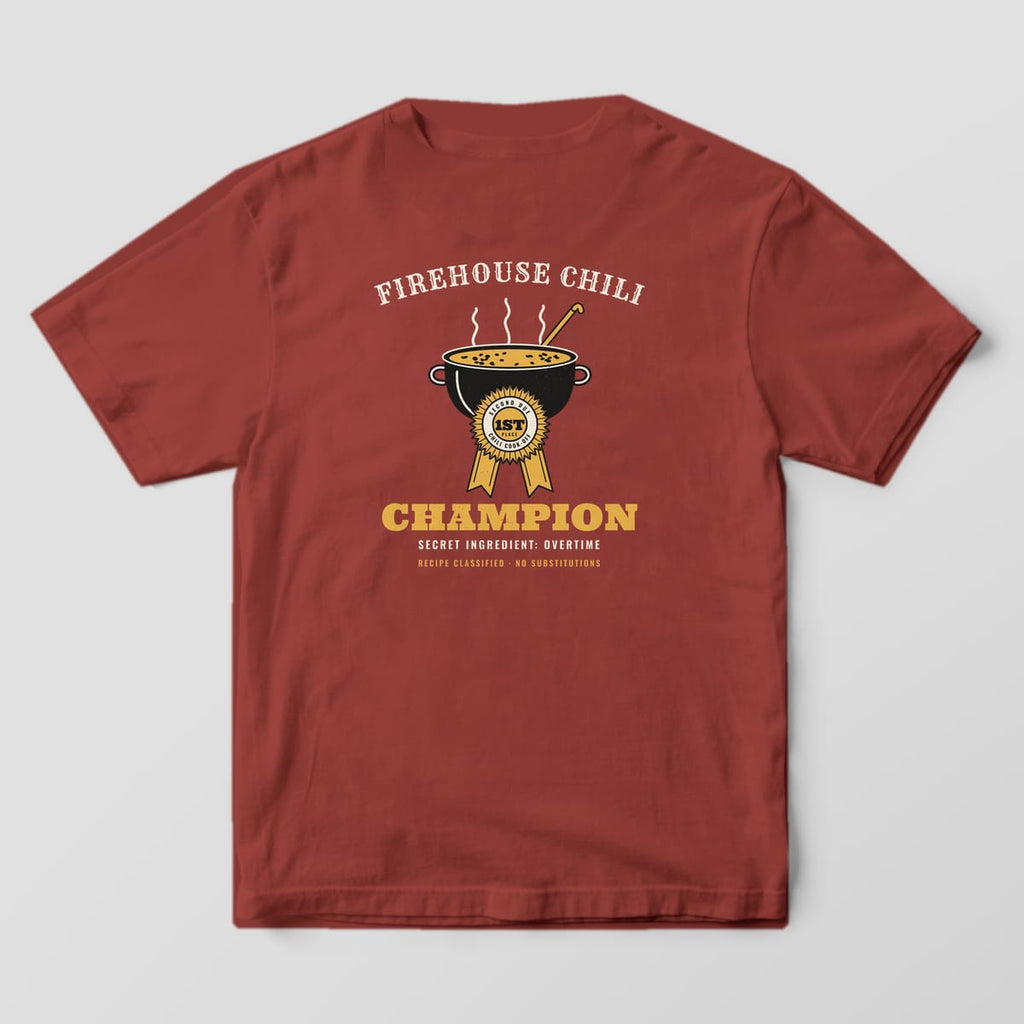 Back of a brick Comfort Colors tee with a black cast-iron chili pot, gold prize ribbon and Firehouse Chili Champion