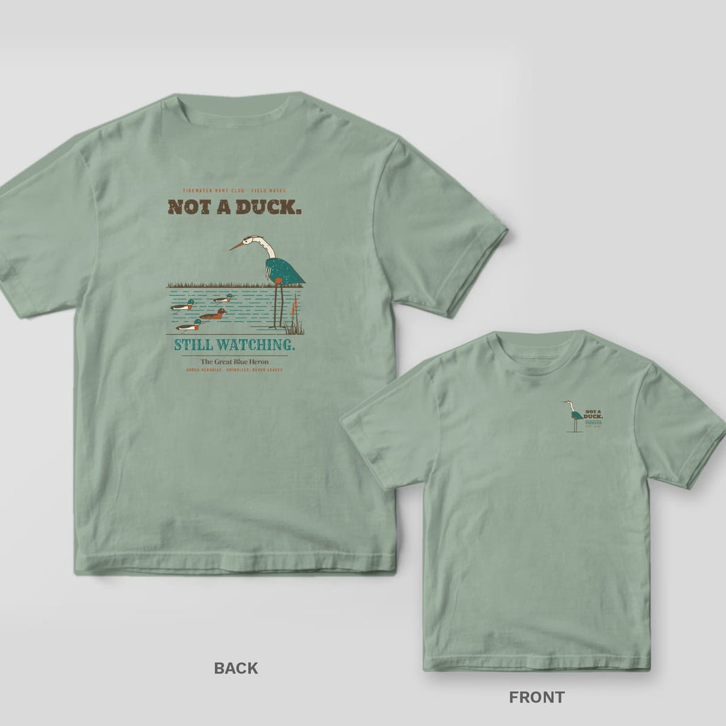 Back and front views of a sage green T-shirt with a heron eyeing duck decoys on the back and a small heron on the chest