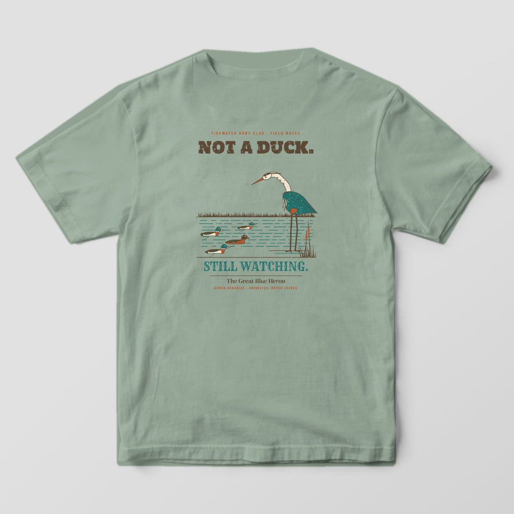 Sage Bay Comfort Colors T-shirt back showing a great blue heron studying mallard decoys under the words Not a Duck
