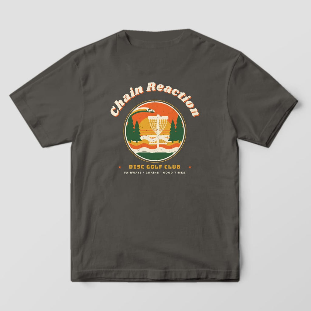 Back of a Pepper Comfort Colors 1717 tee printed with a round retro sunset badge with a disc golf basket and pines under arched Chain Reaction lettering.