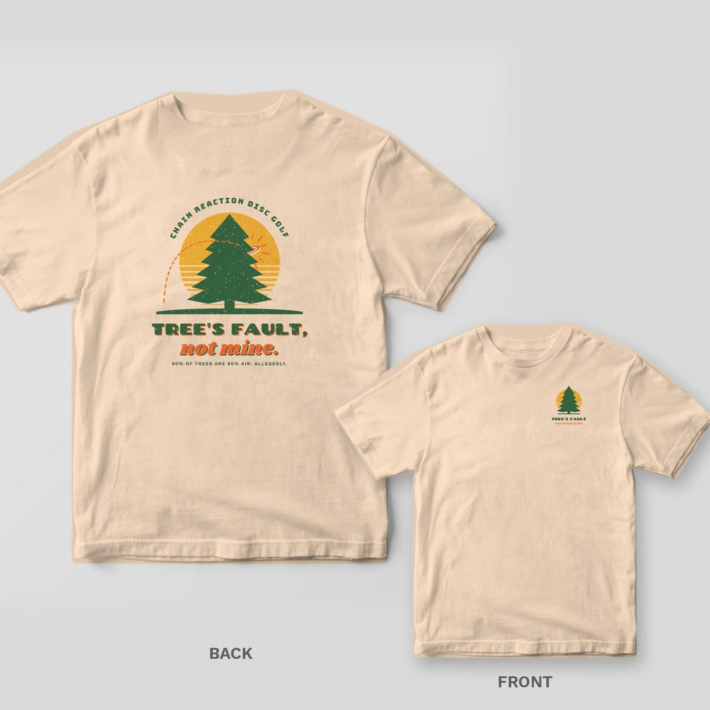 Ivory Comfort Colors tee shown back and front: a forest-green pine against a mustard sun with a disc hitting it and the words Tree's Fault, not mine on the back, a small pine and sun icon with Tree's Fault text on the chest.