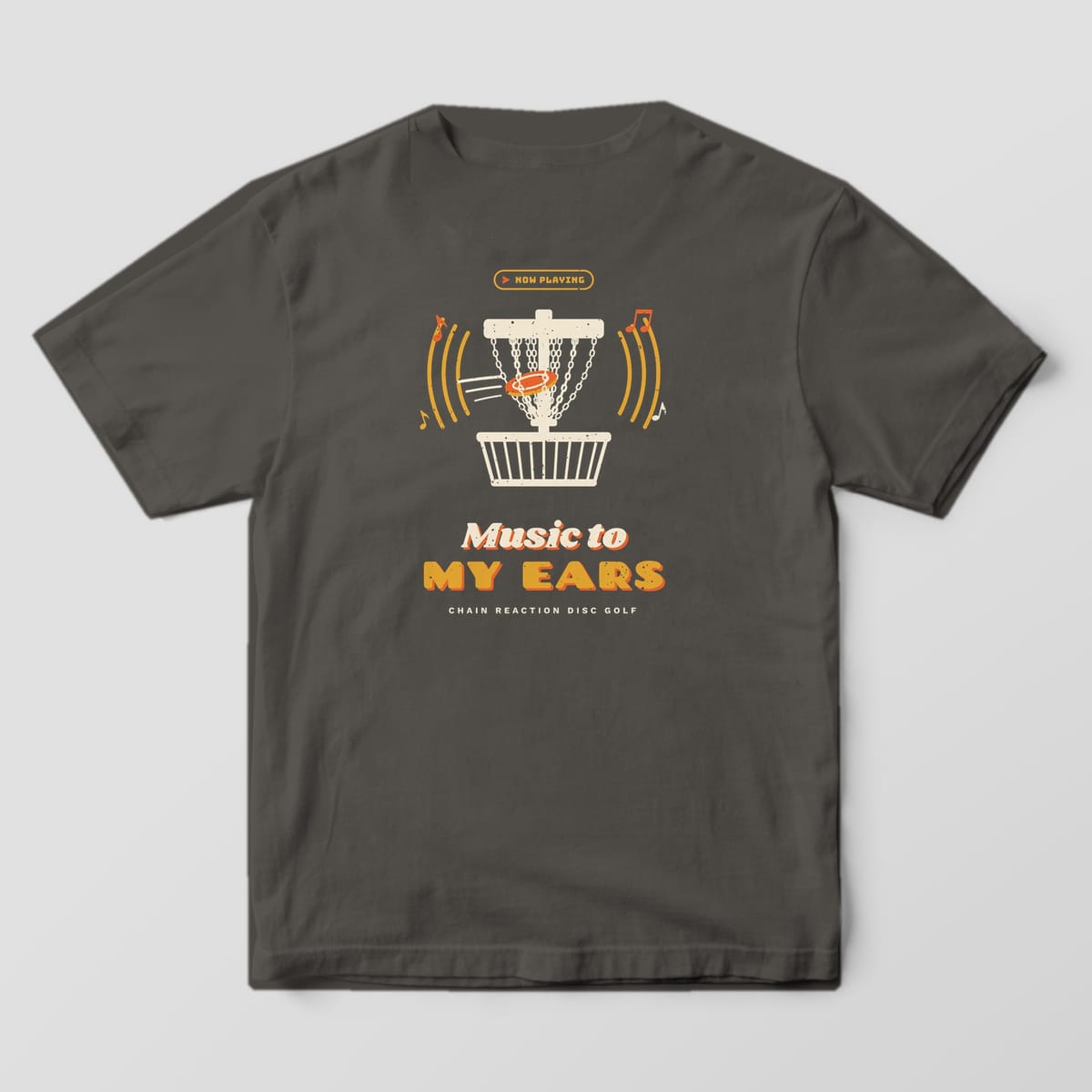 Back of a Pepper Comfort Colors 1717 tee printed with a cream disc golf basket with a disc hitting the chains, mustard sound waves and music notes, and the words Music to My Ears.