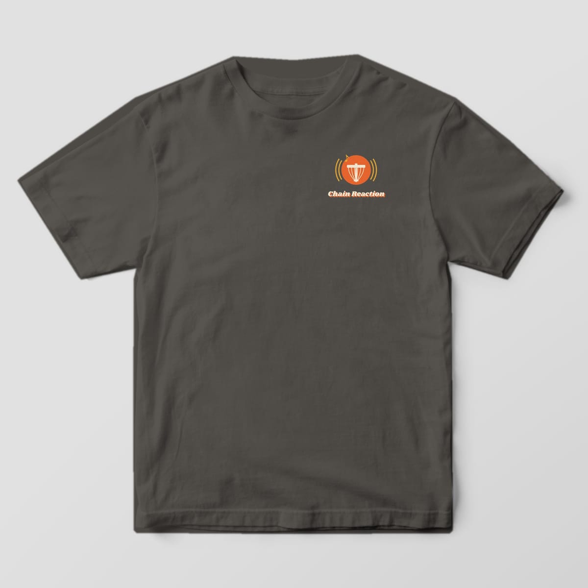 Front of a Pepper Comfort Colors 1717 tee with a small chains icon with sound waves and the Chain Reaction wordmark on the left chest.