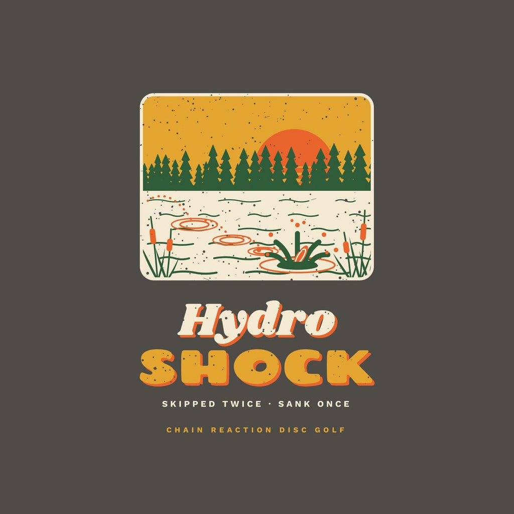 Close-up of the back print artwork: a framed retro pond scene with pines, cattails and a disc skipping into the water above the words Hydro Shock, with retro speckled texture.