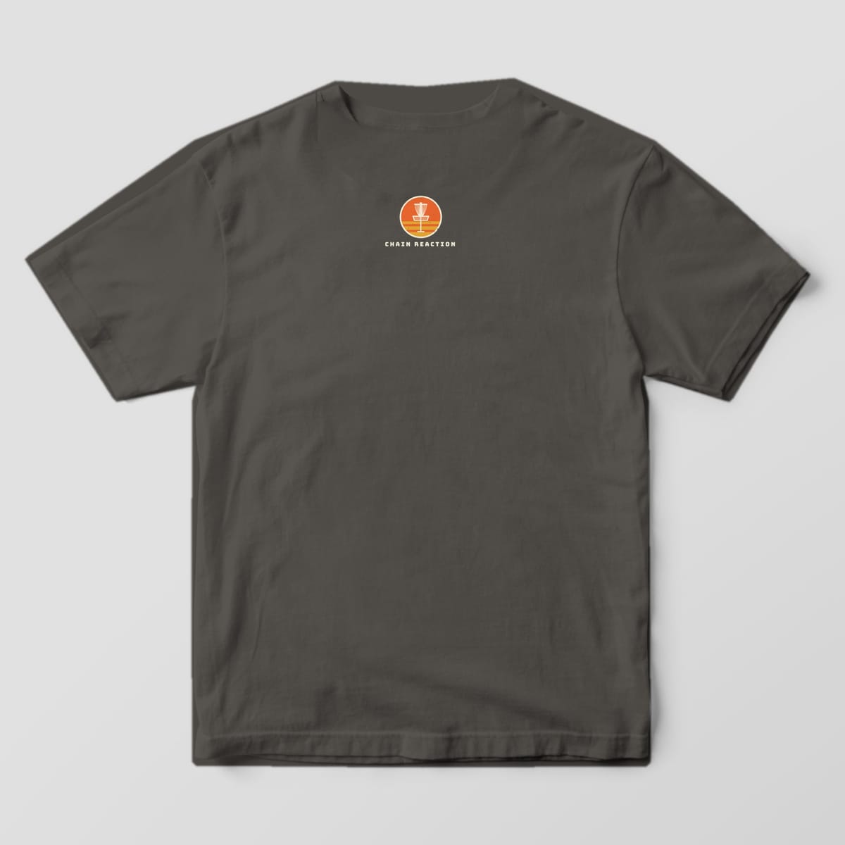 Back of a pepper Comfort Colors t-shirt with a small orange sunset basket badge under the collar
