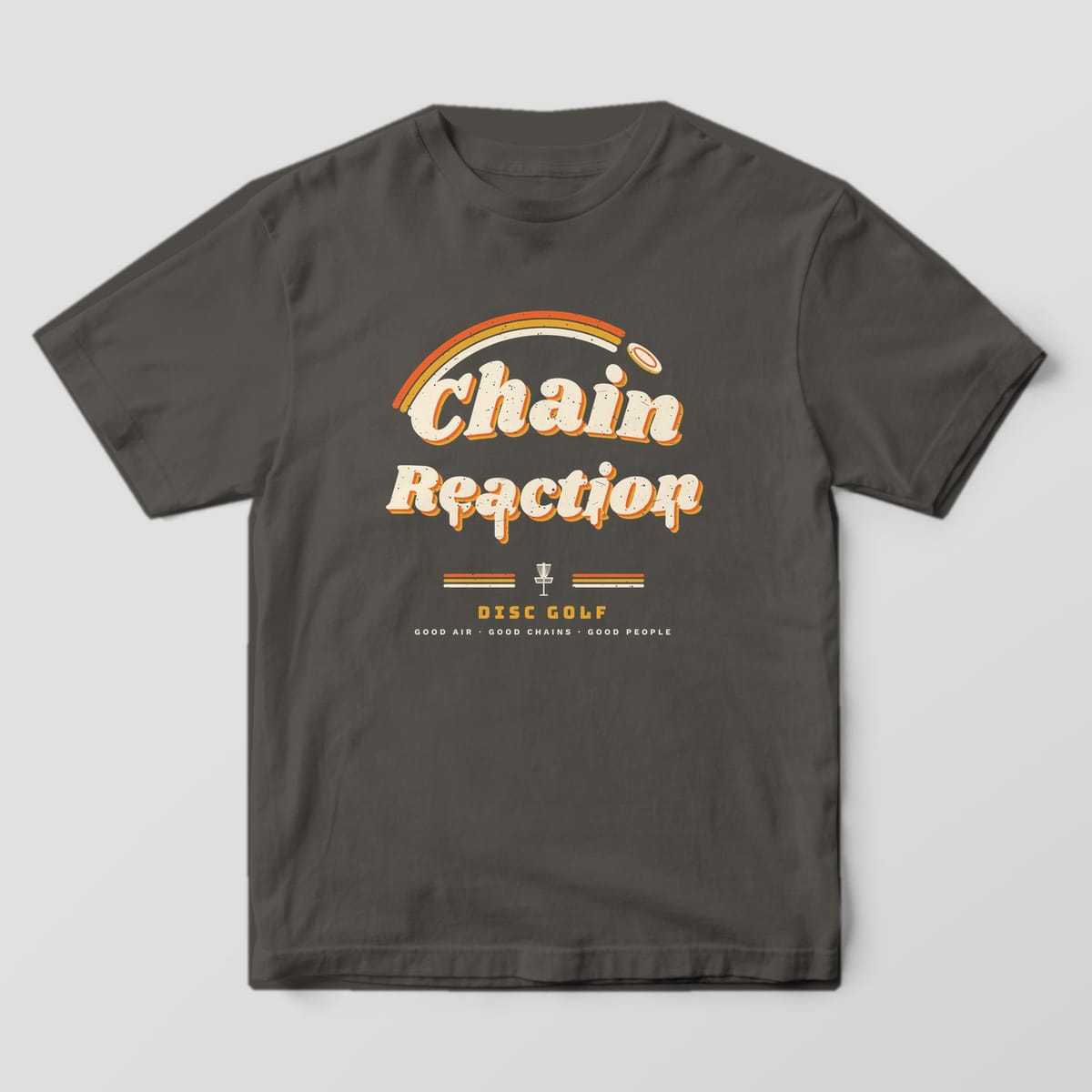 Front of a pepper Comfort Colors t-shirt with a large retro Chain Reaction wordmark, melting letters and a rainbow disc trail
