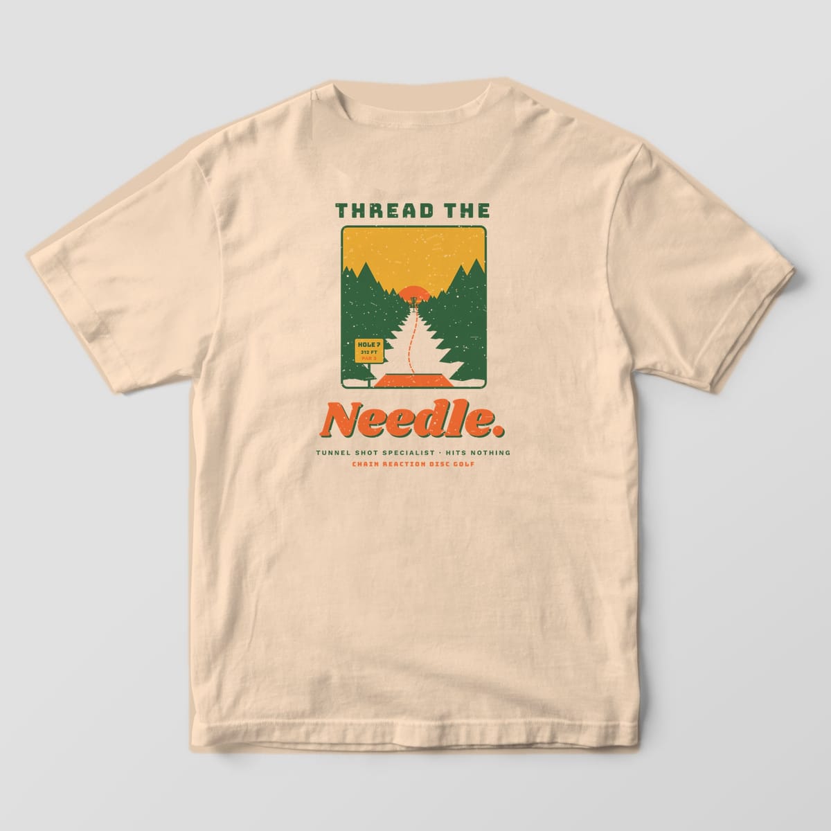 Back of an ivory Comfort Colors t-shirt with a tunnel shot scene through pine trees and the words Thread the Needle