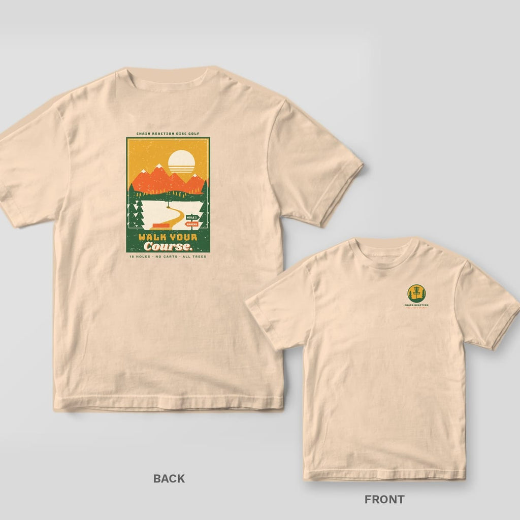 Ivory t-shirt shown back and front: vintage poster with orange mountains, cream sun, green pines and a winding fairway to a basket, Walk Your Course title, basket badge on chest