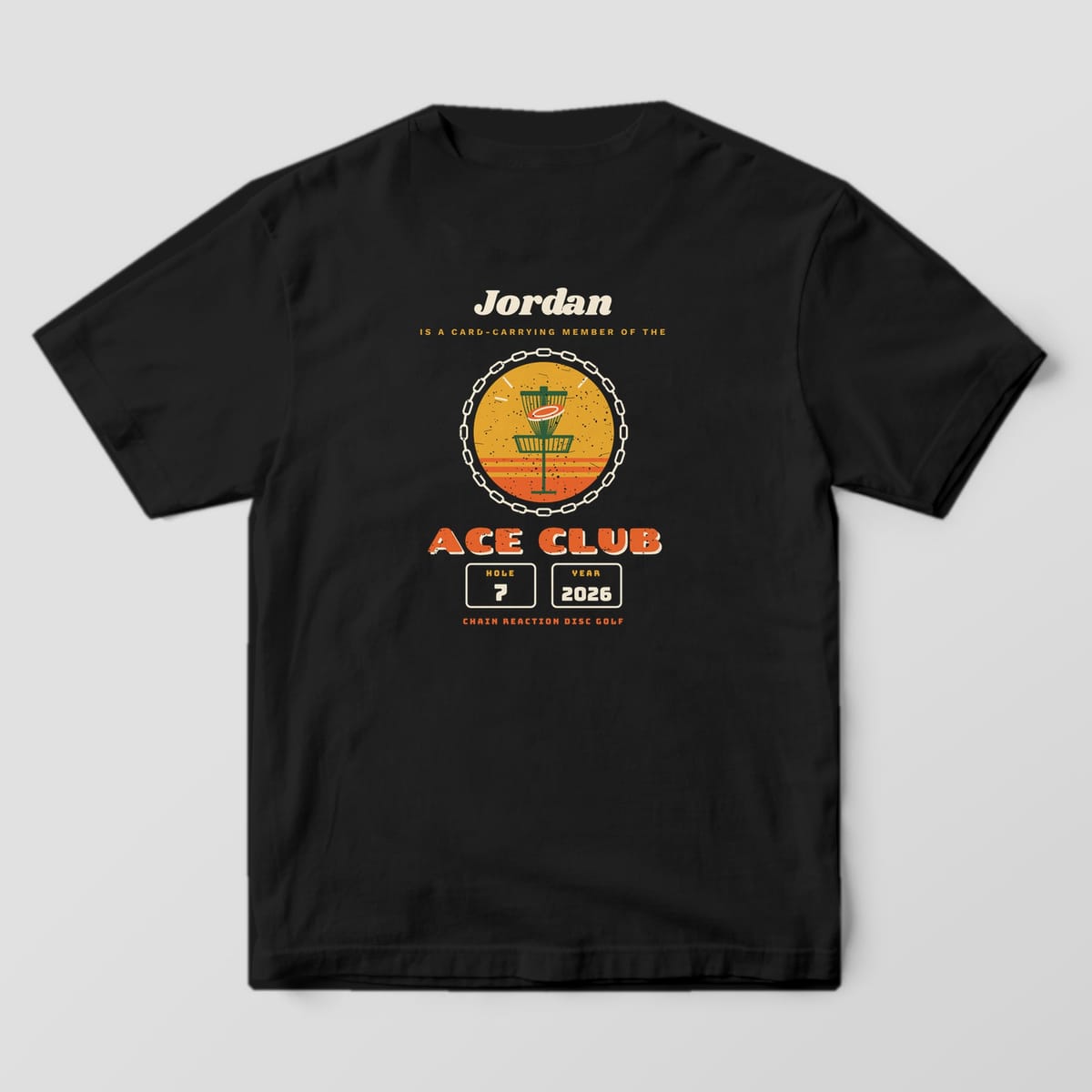 Back of a black Comfort Colors t-shirt with a custom name, disc golf basket badge, Ace Club lettering and hole and year plates