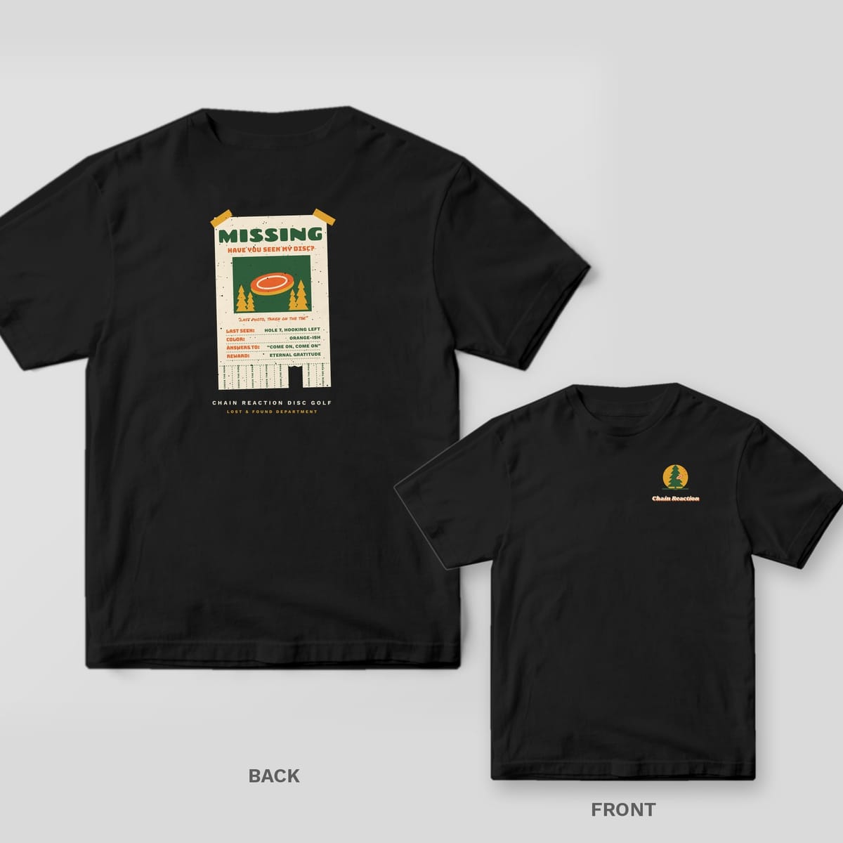 Black Comfort Colors tee shown back and front: a cream taped-up Missing poster with a photo of an orange disc, lost-disc details and tear-off tabs on the back, a small pine tree with a disc stuck in it and the Chain Reaction wordmark on the chest.