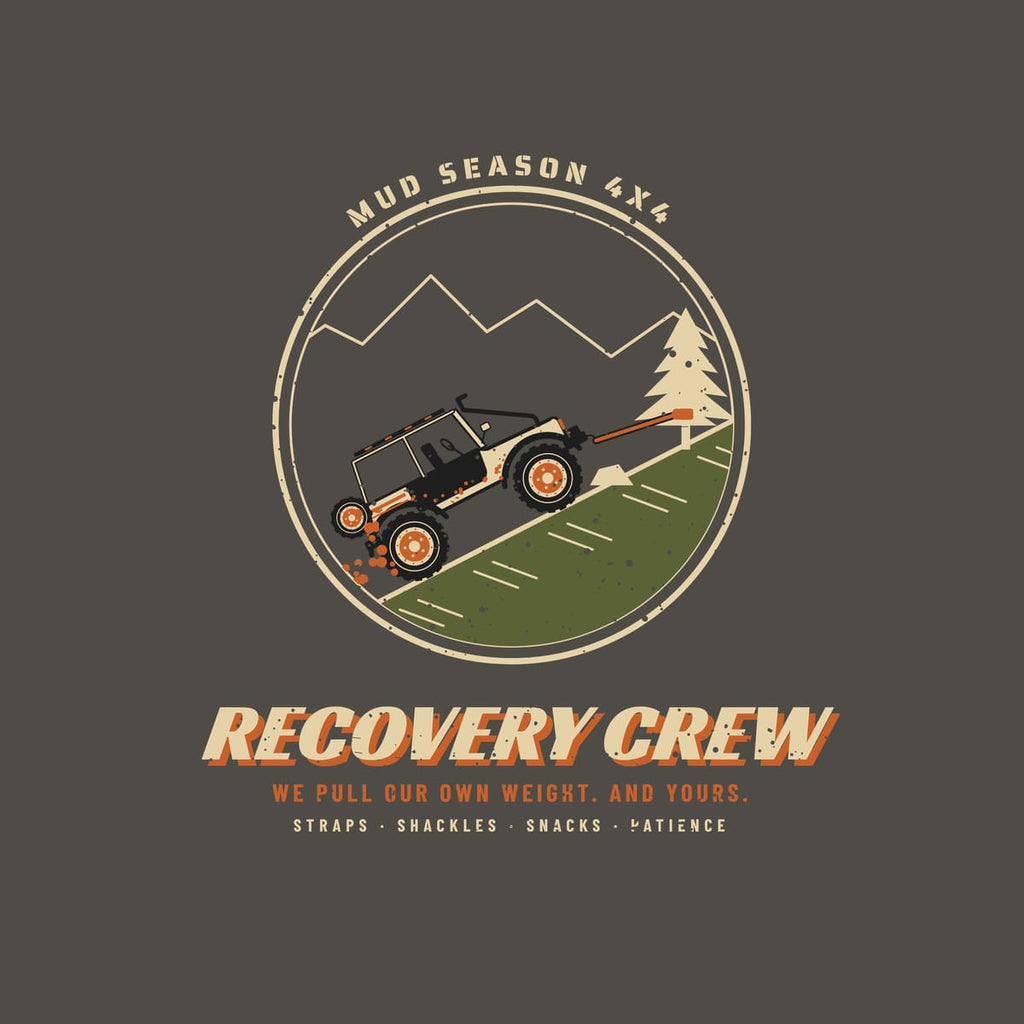 Close-up of the back print artwork, circle badge of a trail rig winching up a hill to a pine tree with Recovery Crew text, on a pepper background