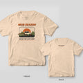 Front and back of an ivory Comfort Colors T-shirt; the front has a full sunset off-road scene with a lifted 4x4, the back has a small Mud Season mark under the collar.