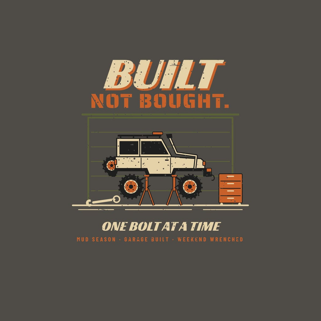 Close-up of the full back artwork: a 4x4 raised on jack stands beside a toolbox, with Built Not Bought and One Bolt at a Time, shown flat on a pepper background.