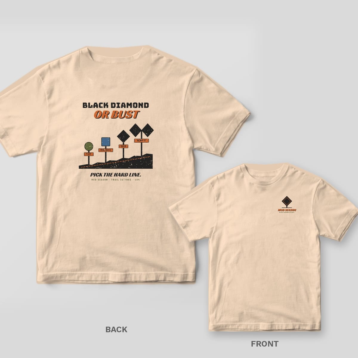 Back and front of an ivory Comfort Colors T-shirt; the back shows four trail rating signs rising up a ridge with Black Diamond or Bust lettering, the front has a small diamond sign.