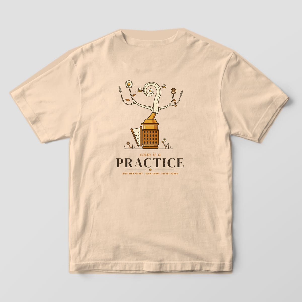 Back of a ivory Comfort Colors 1717 T-shirt printed with a vintage bee smoker whose smoke curls into wildflowers above the words calm is a practice.