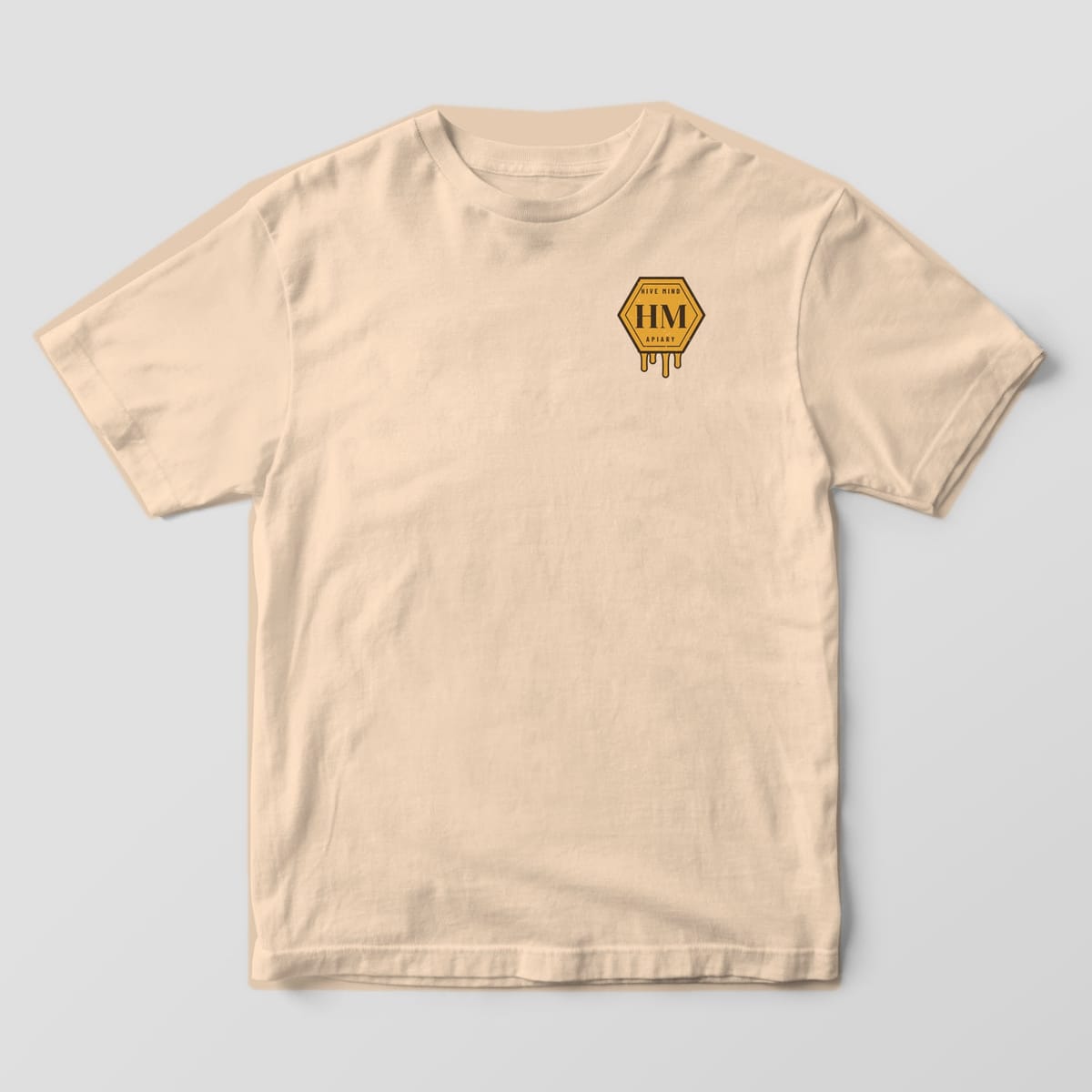 Front of a ivory Comfort Colors 1717 T-shirt with a small Hive Mind Apiary left-chest print.