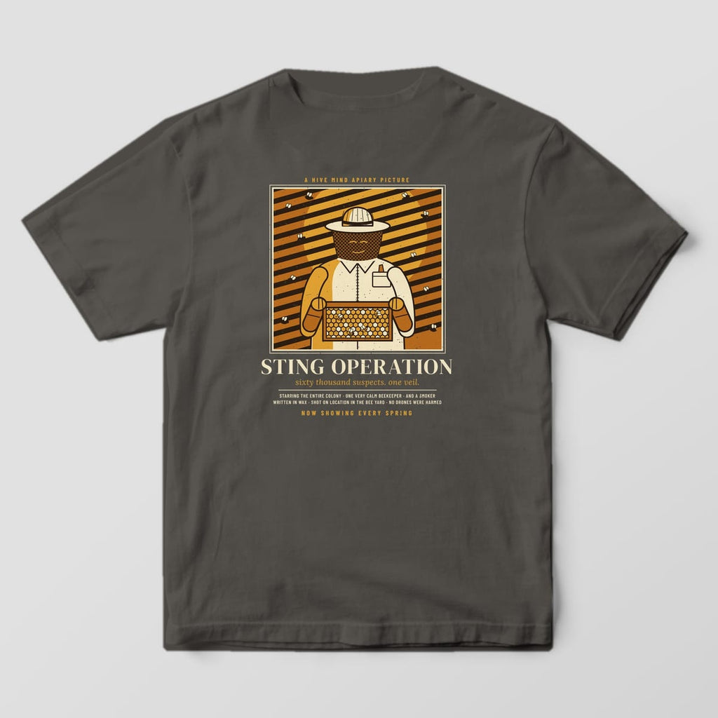 Back of a pepper Comfort Colors 1717 T-shirt printed with a film noir style poster of a beekeeper holding a comb frame titled Sting Operation.