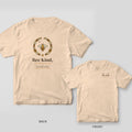 Back and front of a ivory Comfort Colors T-shirt; the back shows a honey bee inside a wildflower wreath above the words Bee Kind, bee calm, bee gentle, the front has a small left-chest print.