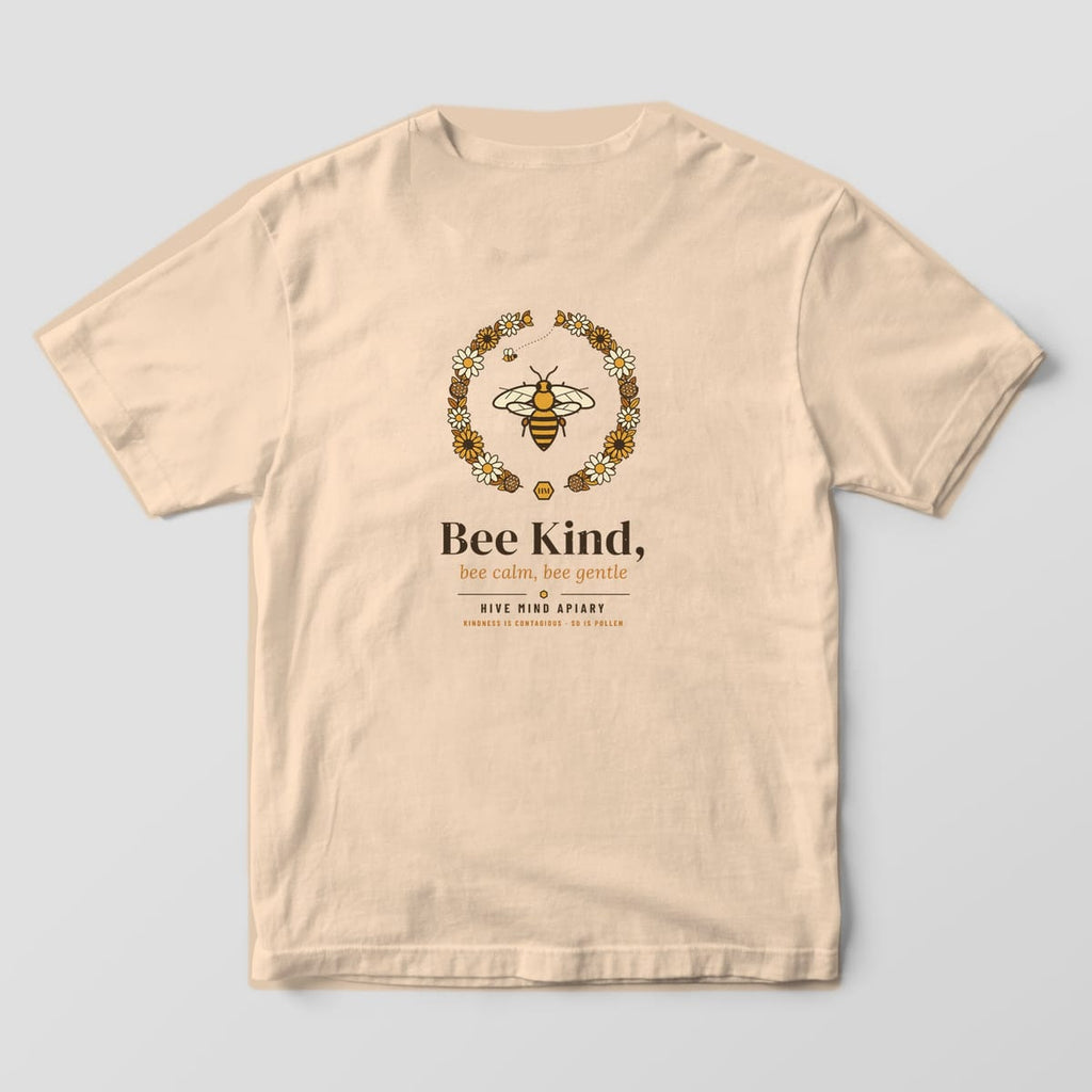 Back of a ivory Comfort Colors 1717 T-shirt printed with a honey bee inside a wildflower wreath above the words Bee Kind, bee calm, bee gentle.