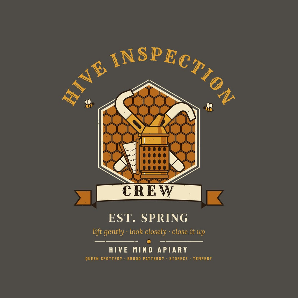 Close-up of the full back artwork: a crest of crossed hive tools and a bee smoker on a honeycomb hexagon titled Hive Inspection Crew, shown flat on a pepper background.