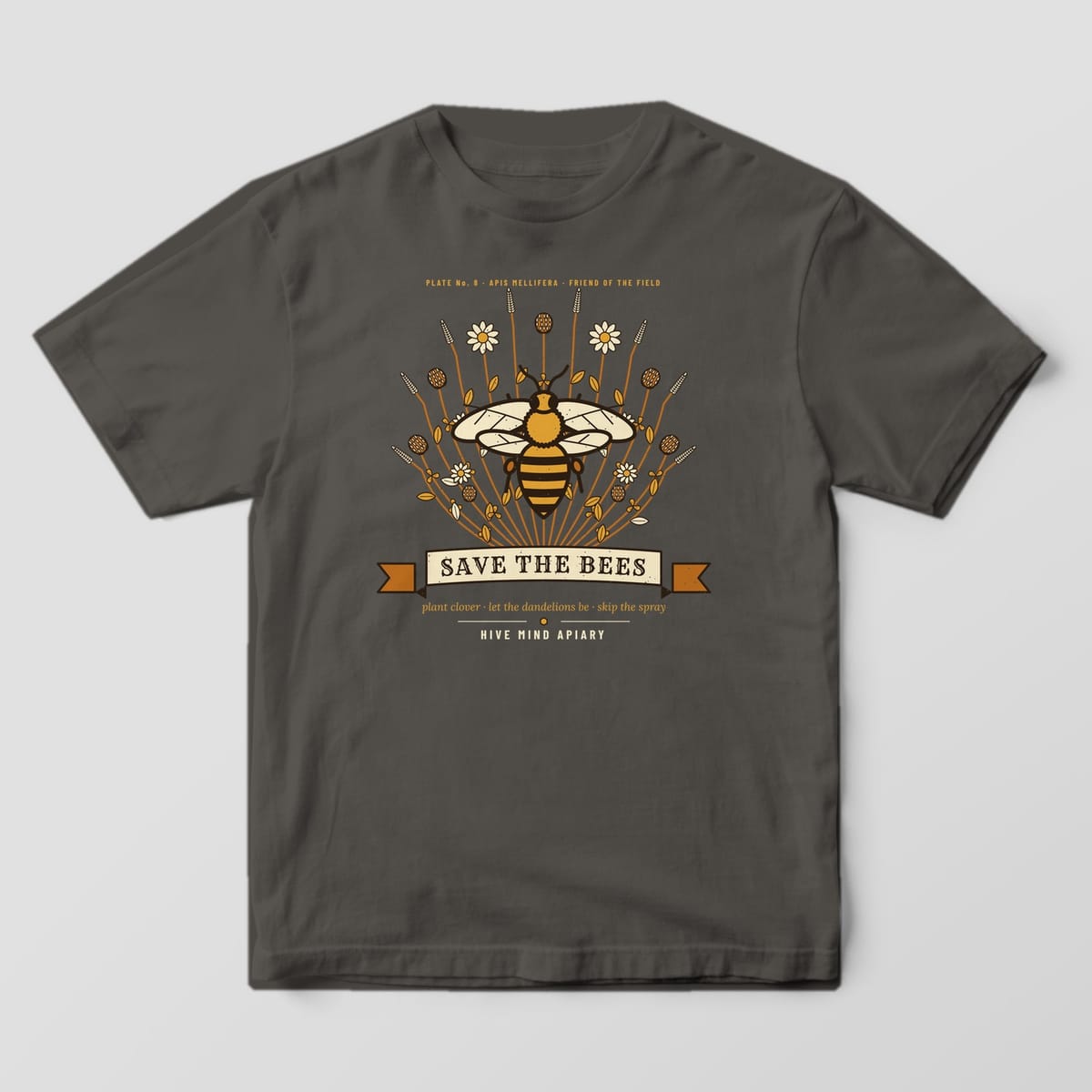 Front of a pepper Comfort Colors T-shirt with a full-front print of a large honey bee over clover and lavender with a Save The Bees ribbon.