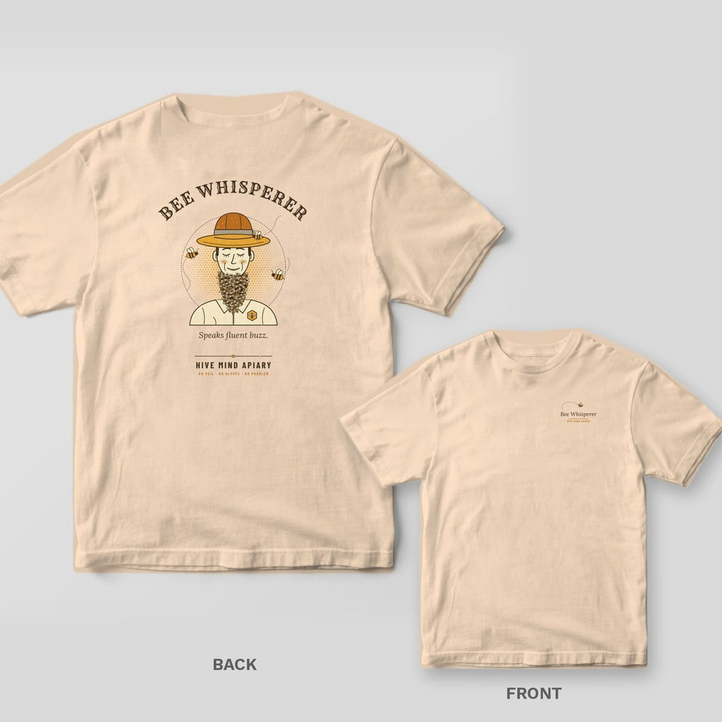 Back and front of an ivory Comfort Colors T-shirt; the back shows a retro portrait of a smiling beekeeper with a beard made of bees, titled Bee Whisperer, the front has the words Bee Whisperer with a small flying bee on the left chest.