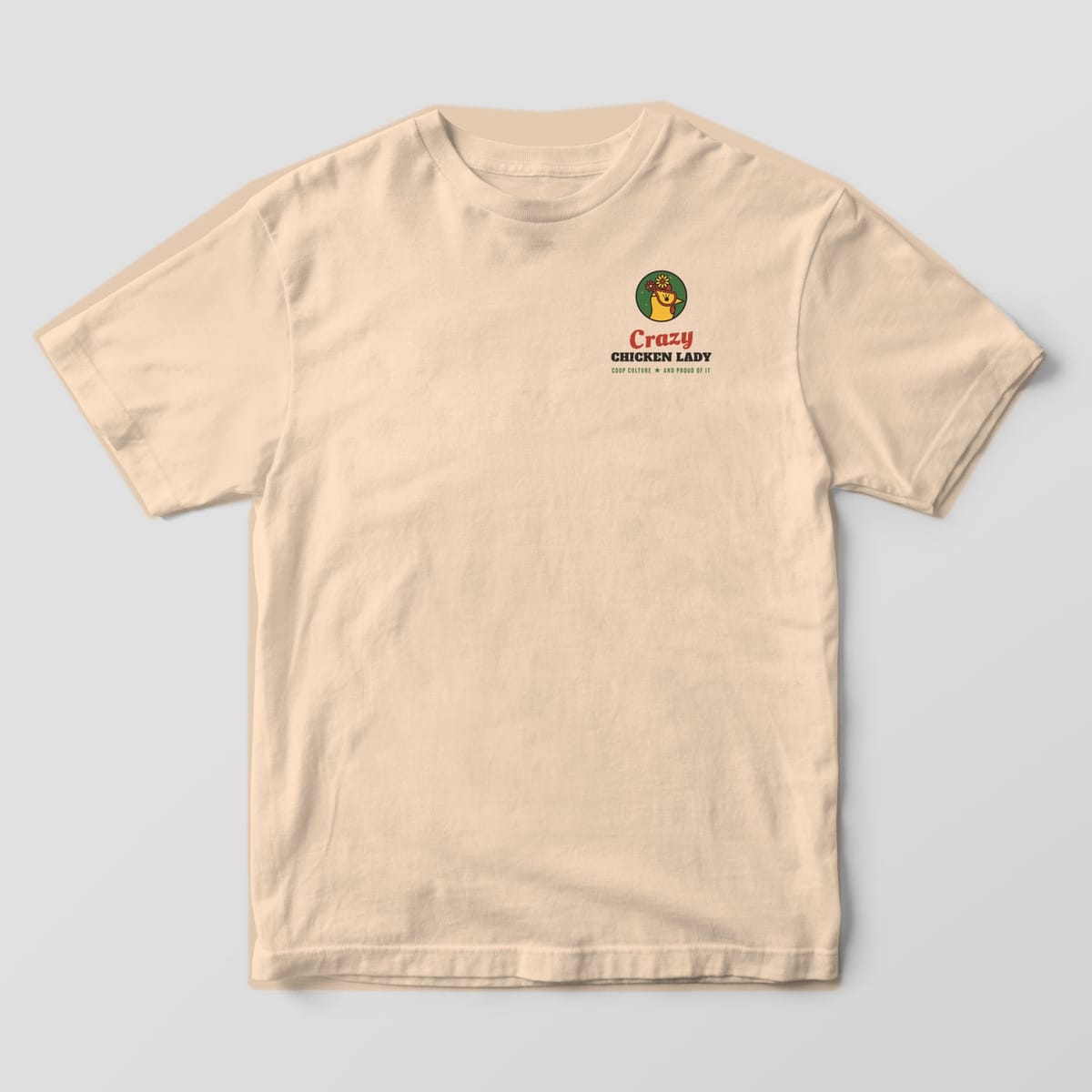 Front of an ivory Comfort Colors 1717 tee with a small hen-in-glasses badge and Crazy Chicken Lady script on the left chest.