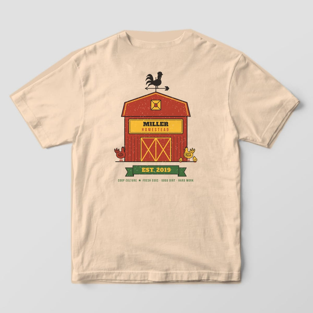 Back of an ivory Comfort Colors 1717 tee with a personalized red barn reading Miller Homestead and an Est. 2019 green ribbon.