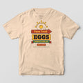 Front of an ivory Comfort Colors tee with a full-front retro diner sign reading Farm Fresh Eggs Sunny Side Up under a fried egg sunrise.
