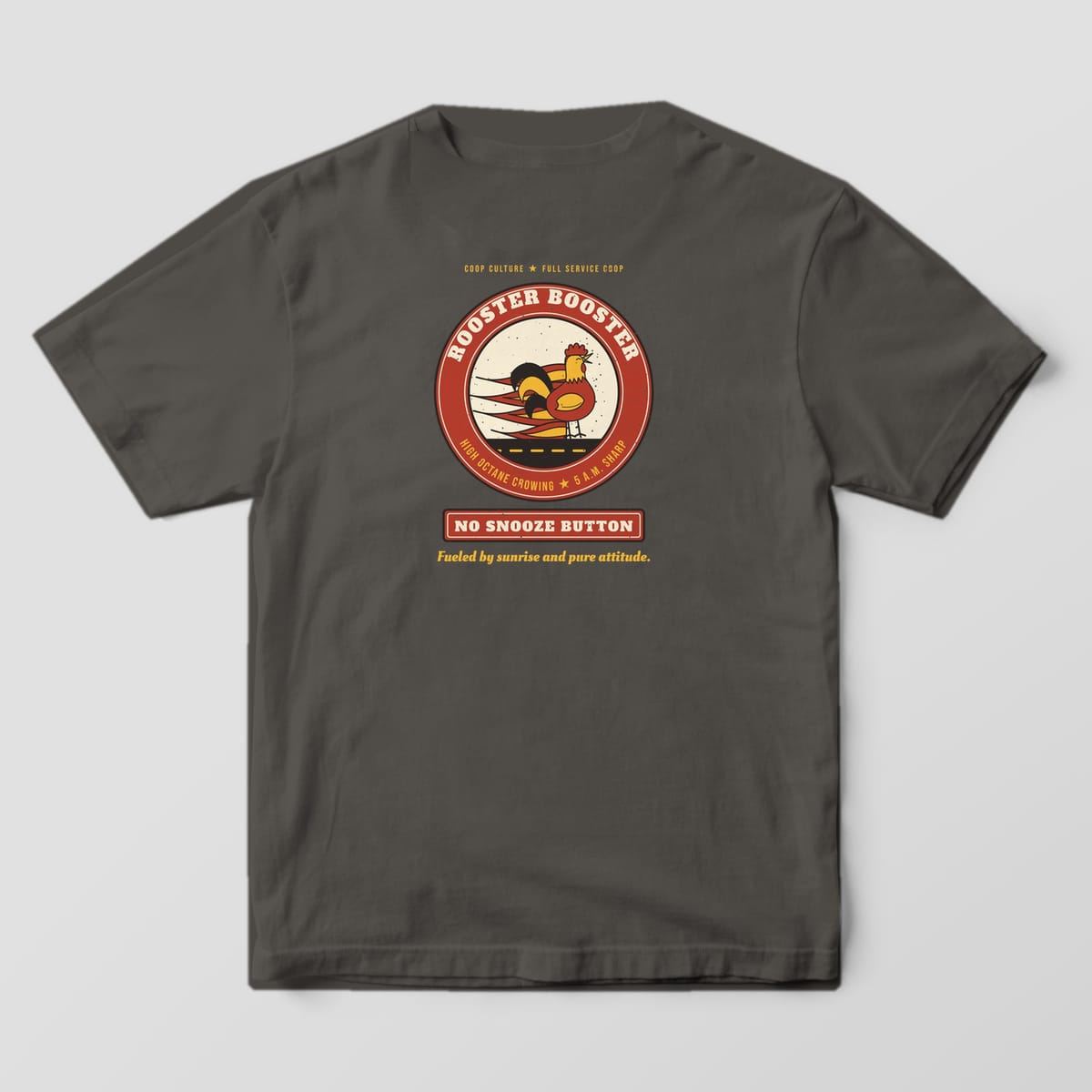 Back of a pepper Comfort Colors 1717 tee with a red and cream Rooster Booster badge, a crowing rooster with flames and a No Snooze Button sign.