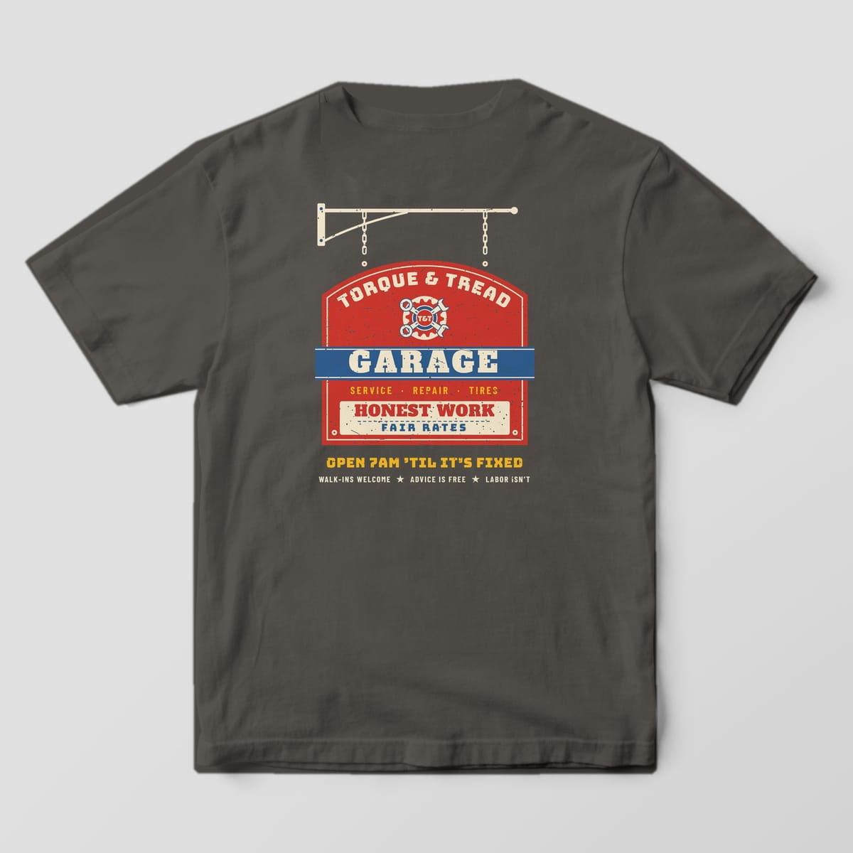 Back of a Pepper Comfort Colors 1717 tee with the red, blue and cream hanging garage sign print with crossed wrenches, the word Garage and Honest Work, Fair Rates.