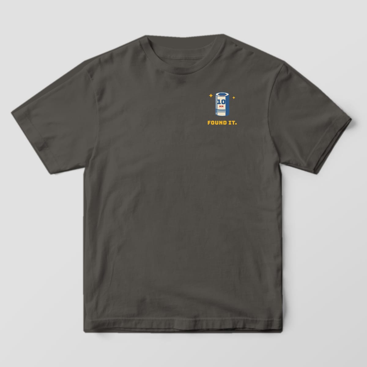 Front of a Pepper Comfort Colors 1717 tee with a small 10mm socket icon with sparkles above the words Found It on the left chest.