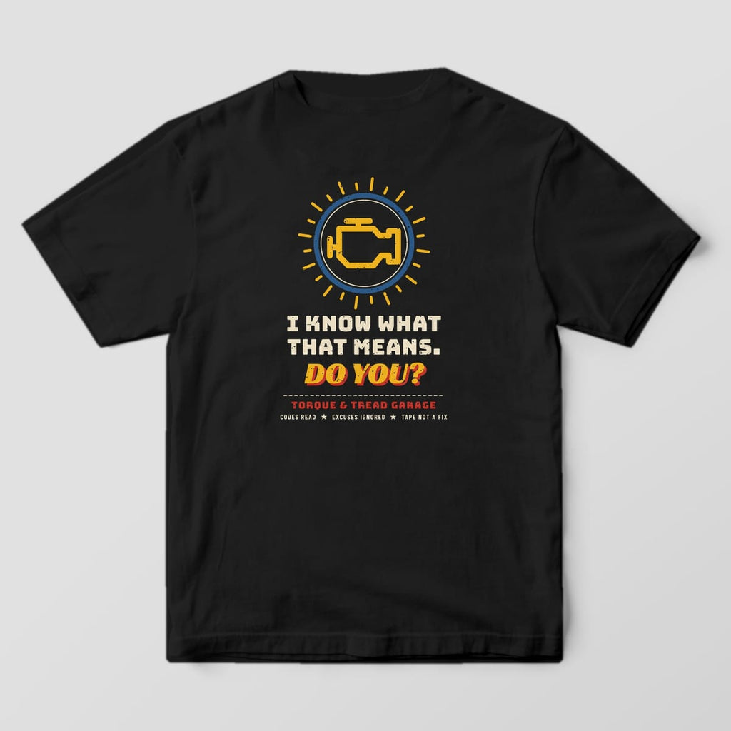 Back of a Black Comfort Colors 1717 tee with the yellow check-engine light in a blue ring with glow rays over cream and yellow lettering reading I Know What That Means. Do You?.