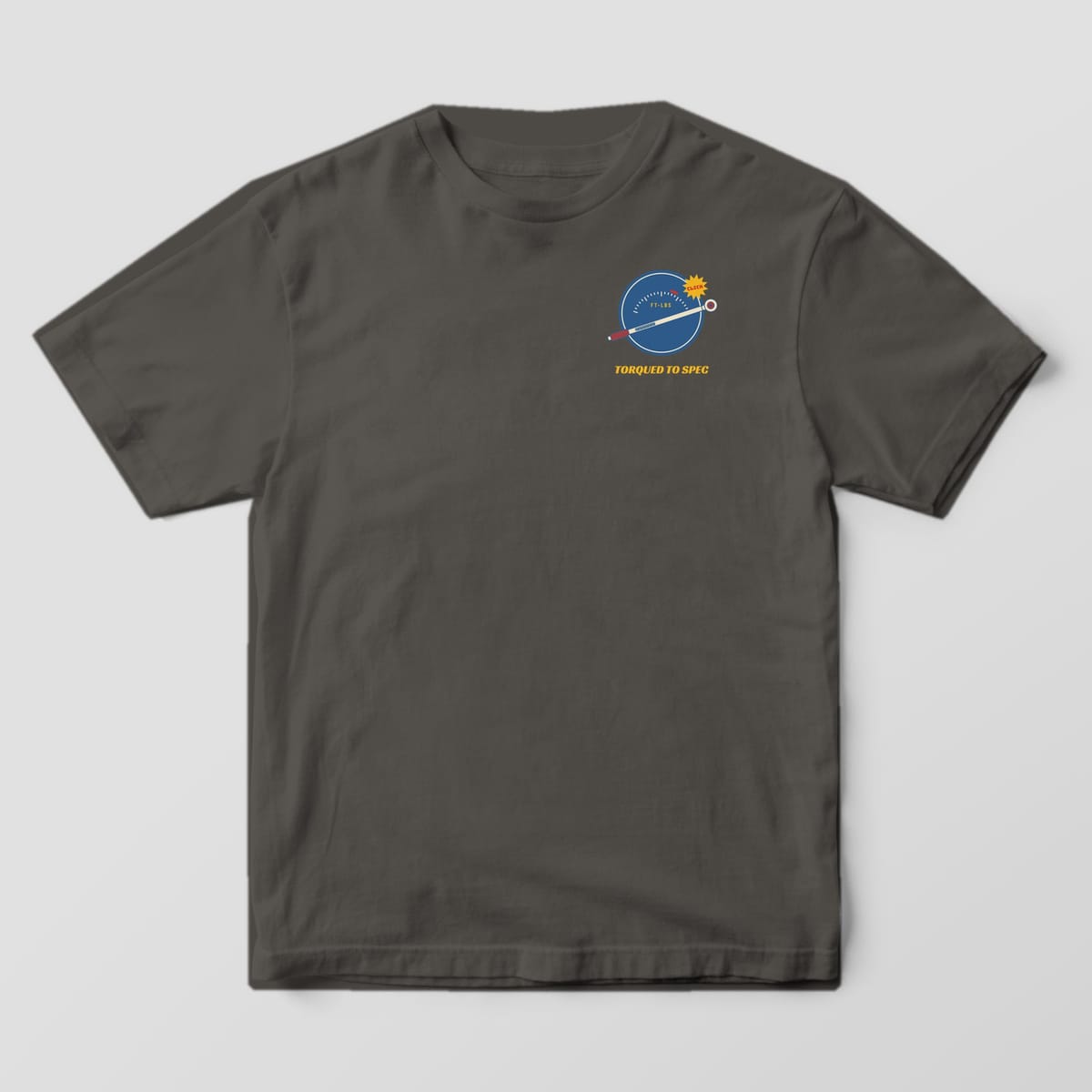 Front of a Pepper Comfort Colors 1717 tee with a small blue gauge and torque wrench above the words Torqued To Spec on the left chest.