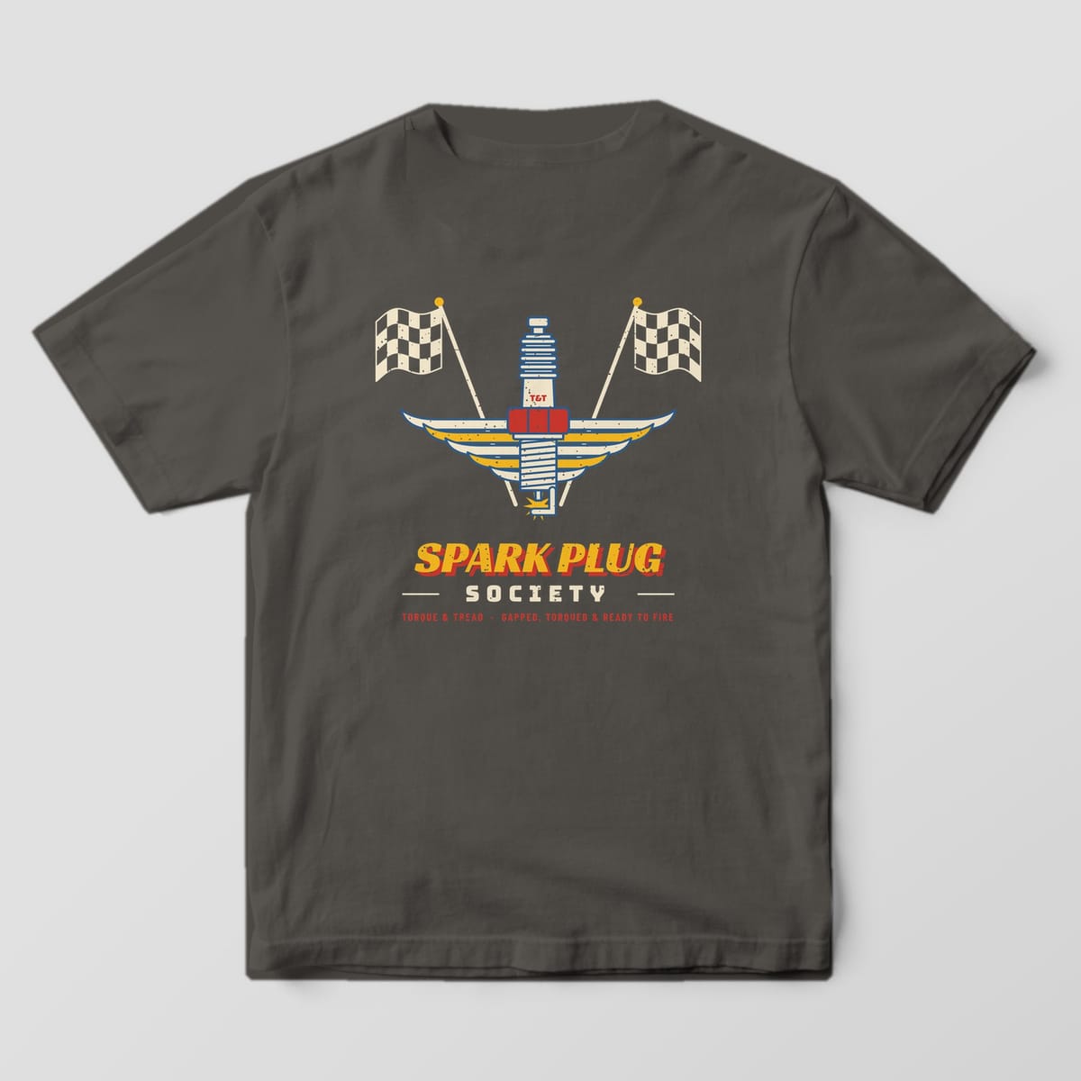 Back of a Pepper Comfort Colors 1717 tee with the cream and blue spark plug with a red hex nut and layered cream and yellow wings, crossed checkered flags and the words Spark Plug Society.
