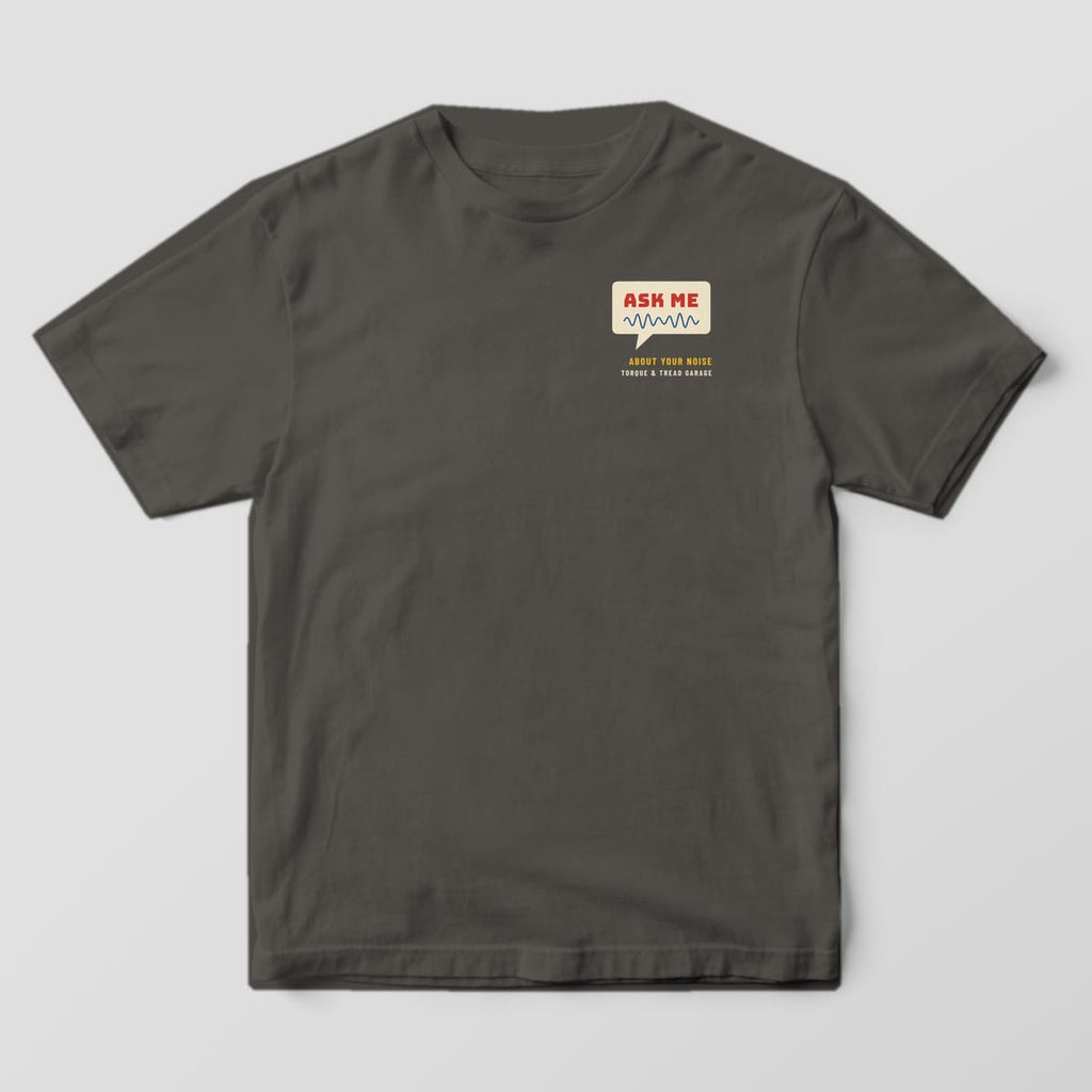 Front of a Pepper Comfort Colors 1717 tee with a small cream speech bubble reading Ask Me with a blue sound wave on the left chest.