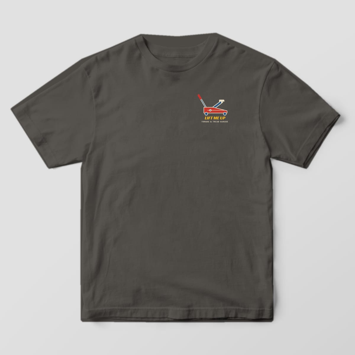 Front of a Pepper Comfort Colors 1717 tee with a small red floor jack and the words Lift Me Up on the left chest.