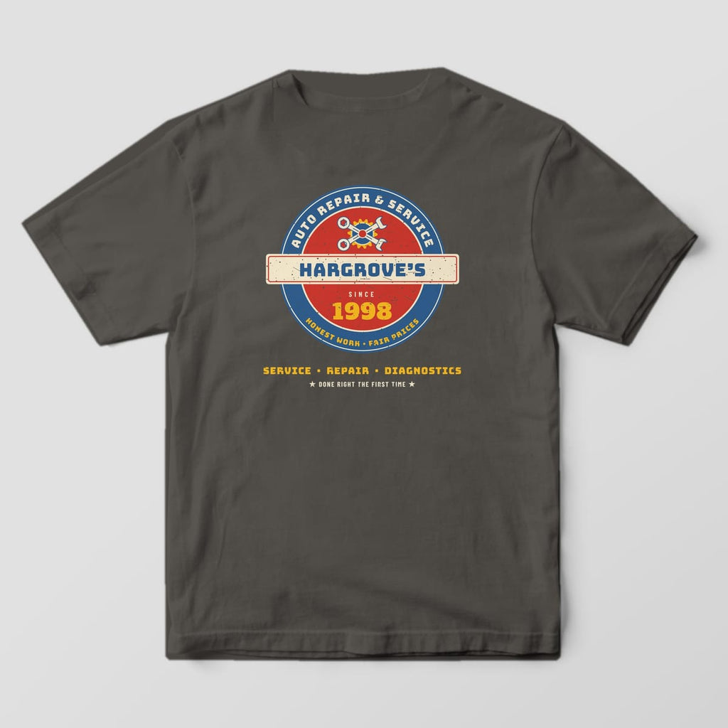 Back of a Pepper Comfort Colors 1717 tee with the vintage porcelain-style roundel sign reading Hargrove's Auto Repair & Service, Since 1998, with crossed wrenches.