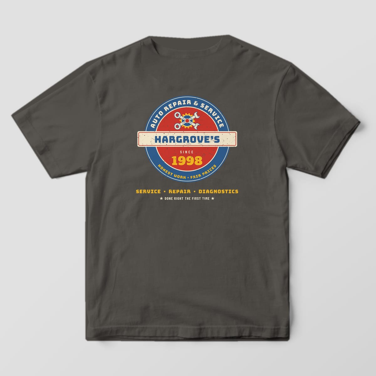 Back of a Pepper Comfort Colors 1717 tee with the vintage porcelain-style roundel sign reading Hargrove's Auto Repair & Service, Since 1998, with crossed wrenches.