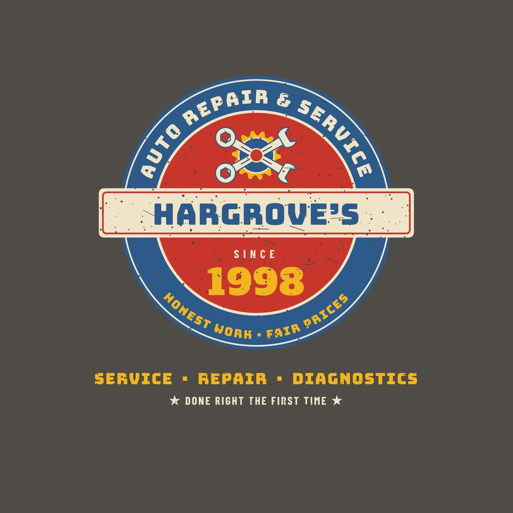 Close-up of the print: blue and red porcelain-style roundel with cream ring text, crossed wrenches over a yellow gear, a cream name bar with blue lettering and a yellow year, with light speckled distressing.