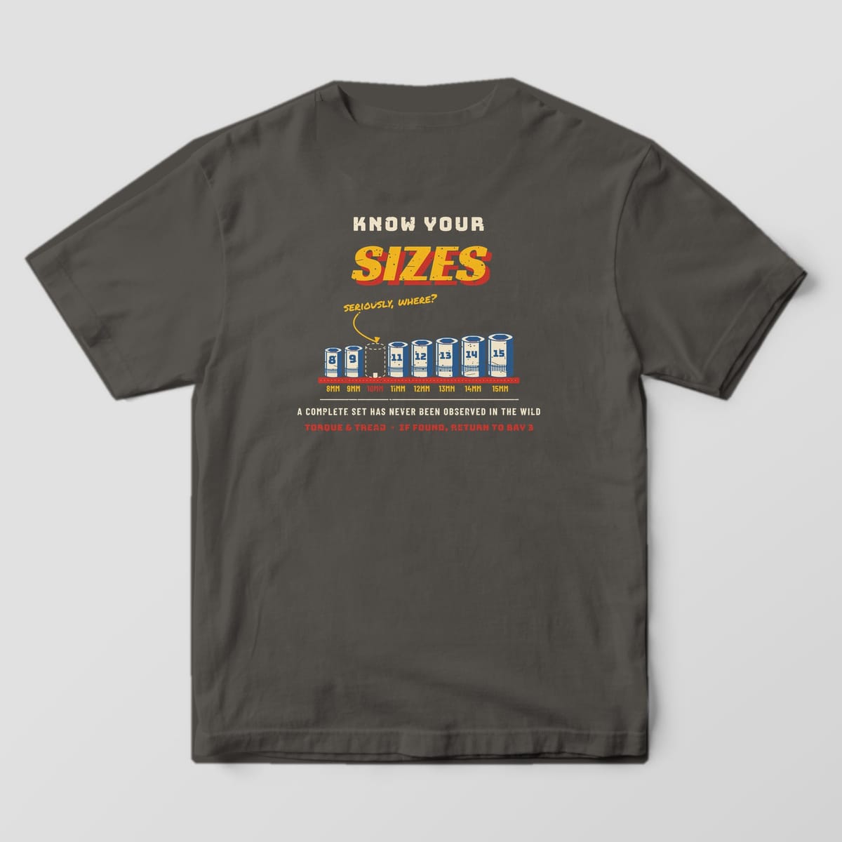 Back of a Pepper Comfort Colors 1717 tee with the row of chrome sockets from 8mm to 15mm on a red rail with the 10mm missing and a marker note asking seriously, where.