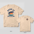 Ivory tee with a leaping lab over a retro sunset and Send It on the back, small life-ring dog badge on the front chest