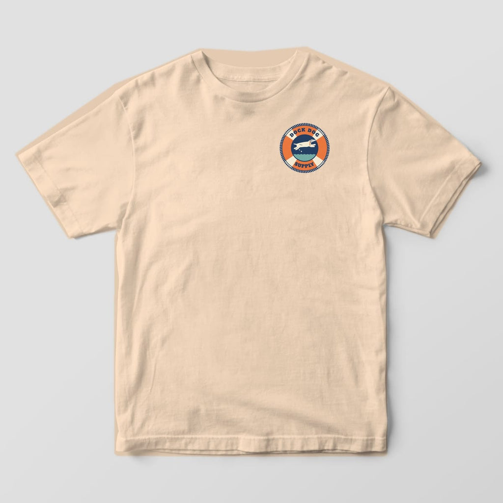 Front of an ivory Comfort Colors tee with a small orange and cream life-ring badge with a leaping dog