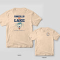 Ivory tee with Smells Like Lake stacked type and a grinning wet lab wearing a lily pad on the back, bone and oar crest on the front