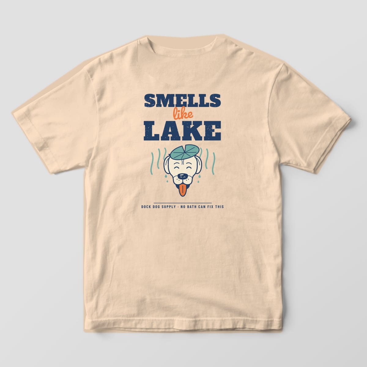 Back of an ivory Comfort Colors tee with bold navy Smells Like Lake lettering over a happy wet dog with stink lines