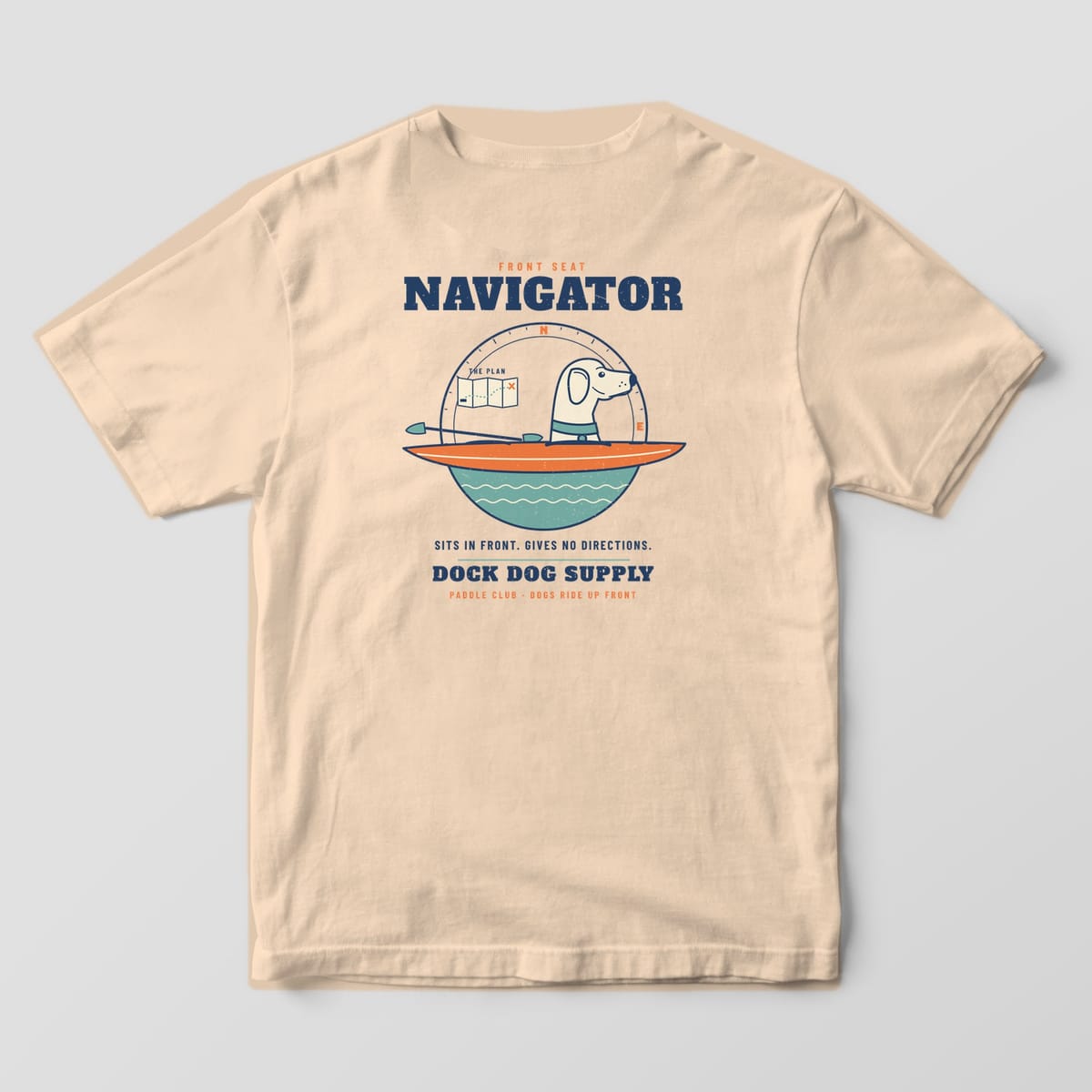 Back of an ivory Comfort Colors tee with a cream lab in an orange kayak, compass ring, folded map and Navigator